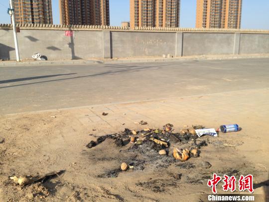 親人在何建華遇害處燃燒的紙錢(qián)和祭品?！⊥跆熳g攝