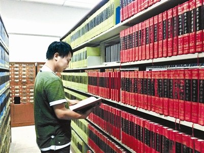 資料圖：一名古籍愛好者正在北大古籍閱覽室翻看“四庫全書”。圖片來源：北京青年報