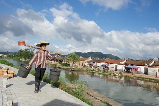 5月27日，埭美村一位村民挑桶經(jīng)過村前小河