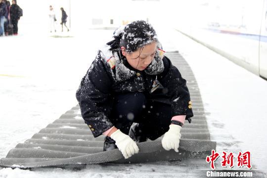 圖為鐵路工作人員在站臺上鋪設(shè)防滑墊?！∏劓z