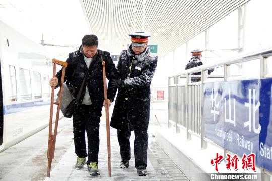 圖為鐵路工作人員幫助旅客進站?！∏劓z