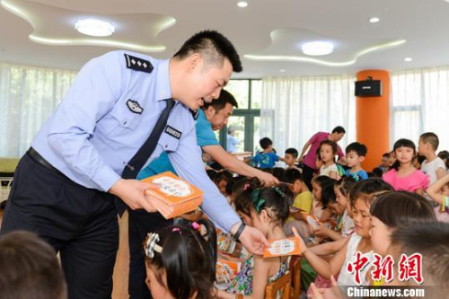 民警向小朋友發(fā)放反拐常識(shí)畫(huà)冊(cè)。陜西警方 供圖