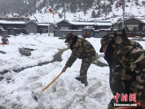 3月11日，西藏公安邊防總隊機動支隊應急二分隊官兵正在鏟除道路積雪。 張鈺 攝