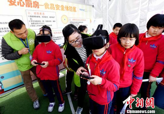 活動現(xiàn)場，小學生通過VR(虛擬現(xiàn)實)技術設備模擬廚房場景，在互動中學習生熟分開，菜品搭配與油鹽使用的廚房食品安全知識。　記者劉可耕 攝