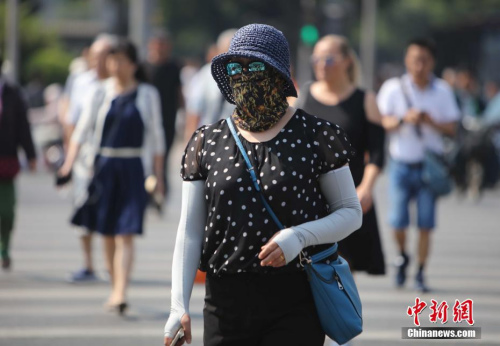 資料圖：5月17日，北京街頭的民眾防曬出行。當日北京市氣象臺發(fā)布今年首個高溫黃色預警。<a target='_blank' href='http://www.chinanews.com/'>中新社</a>記者 楊可佳 攝