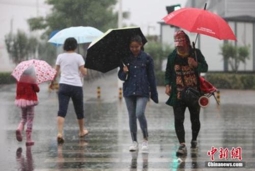 資料圖：民眾在雨中出行。