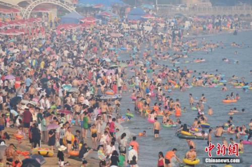 2017年7月12日，青島市第一海水浴場(chǎng)日迎數(shù)萬游客前來避暑納涼。<a target='_blank' href='http://www.chinanews.com/'>中新社</a>發(fā) 王海濱 攝 圖片來源：CNSPHOTO