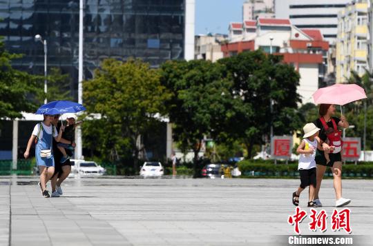 7月13日，廈門市民行走在熱浪滾滾的路面上。　張斌 攝