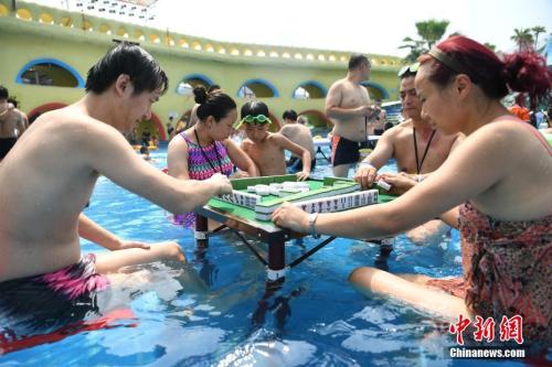 資料圖：2017年8月2日，重慶洋人街一水上樂園舉行夏季消暑活動(dòng)，其中水中玩麻將吸引不少游客參與。陳超 攝