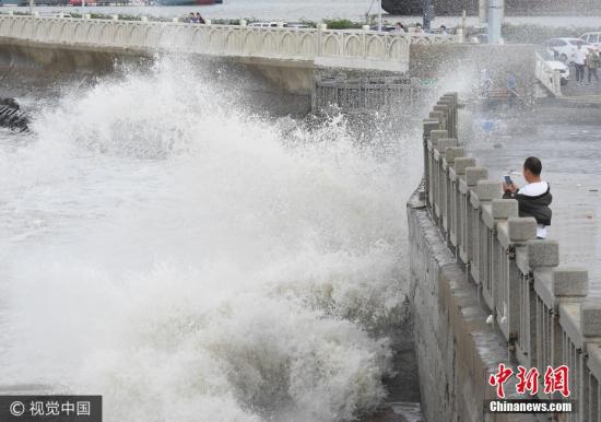 10月2日，游客在連云港市連云區(qū)海岸邊觀賞巨浪。當日，受冷空氣影響，江蘇連云港沿海出現(xiàn)大風，海濱掀起陣陣巨浪。據中央氣象臺預報，10月1日夜間至4日，冷空氣將自北向南影響我國中東部大部地區(qū)，長江中下游及其以北地區(qū)有4-5級風，陣風6-7級，日平均氣溫或最低氣溫將下降4-6℃，北方部分地區(qū)降溫幅度可達10℃以上。耿玉和 攝 圖片來源：視覺中國