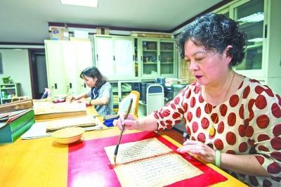 武漢市圖書(shū)館的古籍修復(fù)非遺傳承人賀琳在補(bǔ)缺口