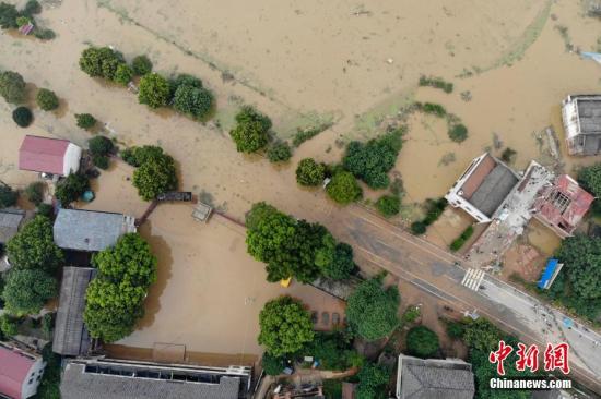 7月11日，湖南衡東縣多個(gè)鄉(xiāng)村與一些道路仍然浸泡在洪水中。連日來(lái)，衡東縣出現(xiàn)了持續(xù)強(qiáng)降雨天氣，造成該縣17個(gè)鄉(xiāng)鎮(zhèn)、233個(gè)村、22個(gè)社區(qū)普遍受災(zāi)。衡東縣防汛抗旱指揮部啟動(dòng)防汛Ⅰ級(jí)響應(yīng)急響應(yīng)。10日，衡東縣霞流鎮(zhèn)洣河村洣水河堤發(fā)生兩處漫堤決口，決口寬度分別約為50米和30米，霞流鎮(zhèn)第一時(shí)間組織附近村民轉(zhuǎn)移。圖為衡山縣通往衡東縣的東健大道被洪水阻斷。楊華峰 攝