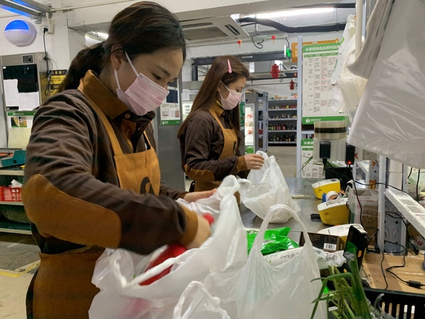 圖為美團(tuán)買(mǎi)菜員工為用戶(hù)分裝訂單菜品。