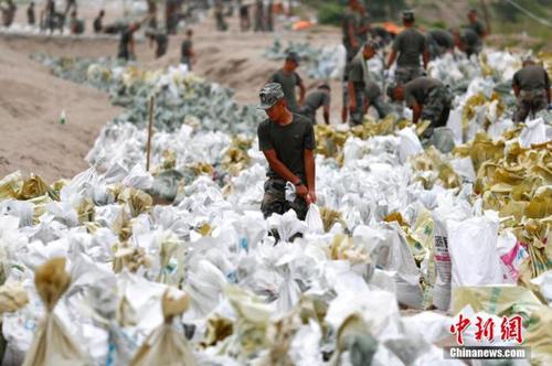 資料圖：7月25日，江西省九江市柴桑區(qū)江洲鎮(zhèn)北堤，中國(guó)人民解放軍第71集團(tuán)軍某部官兵正在為防洪備料。